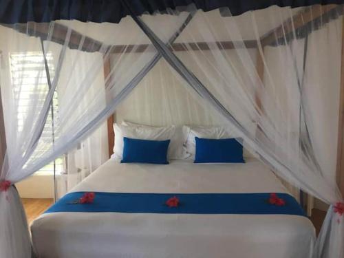 马太洛玛尼度假屋的一间卧室配有一张带蓝色枕头的床