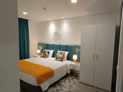 凡道Garden House Fundão - Apartamento 201 com 2 quartos com vista jardim的一间卧室配有一张带橙色毯子的大床