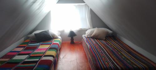 圣卡洛斯-德巴里洛切Cabaña Ermelinda的阁楼卧室设有两张床和窗户。