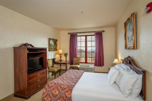 弗吉尼亚城Silverland Inn的一间卧室配有一张床、一台电视和一张书桌