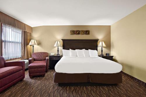 布兰森布兰森潘特贝斯特韦斯特酒店的配有一张床和一把椅子的酒店客房