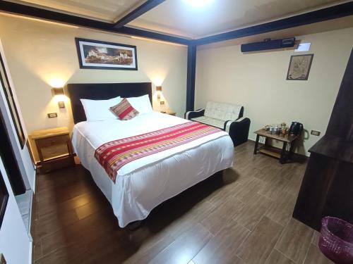 库斯科La Posada del Viajero的一间卧室配有一张大床和一把椅子
