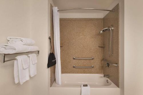 麦迪逊卡尔森麦迪逊乡村套房酒店 的带淋浴、浴缸和毛巾的浴室