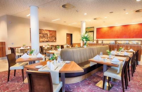 德累斯顿德累斯顿老城莱昂纳多酒店的一间在房间内配有桌椅的餐厅