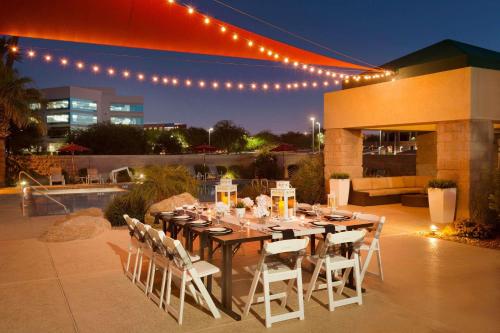 凤凰城菲尼克斯机场雷迪森酒店的晚上在庭院里摆放着餐桌和椅子