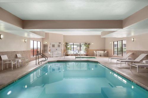 弗拉格斯塔夫弗拉格斯塔夫卡尔森江山套房旅馆的一座配有桌椅的酒店游泳池
