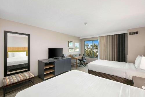 米拉梅萨北圣地亚哥乡村套房酒店的酒店客房配有两张床和一张带镜子的书桌