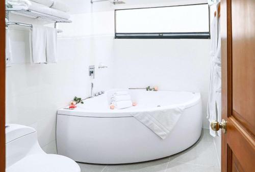 波哥大Radisson Bogota Metrotel的白色的浴室设有浴缸和卫生间。