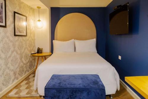 卡利Faranda Collection Cali, a member of Radisson Individuals的一间卧室配有一张白色大床和蓝色的墙壁