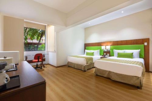 圣何塞圣何塞机场江山套房度假村的酒店客房设有两张床和电视。
