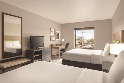 坦帕Country Inn & Suites by Radisson, Tampa Airport East-RJ Stadium的酒店客房,设有两张床和镜子