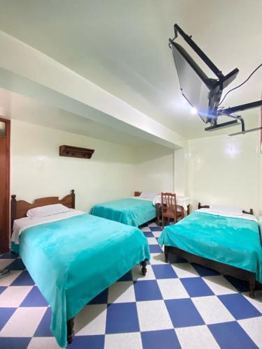 查查波亚斯Hospedaje el Poseidon的一张蓝色的床,位于一个设有 ⁇ 形地板的房间