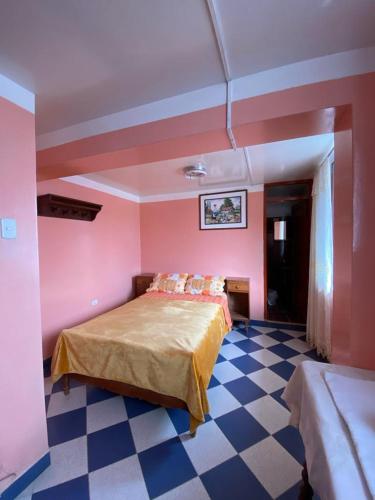 查查波亚斯Hospedaje el Poseidon的一间卧室设有粉红色的墙壁和一张铺有 ⁇ 格地板的床。