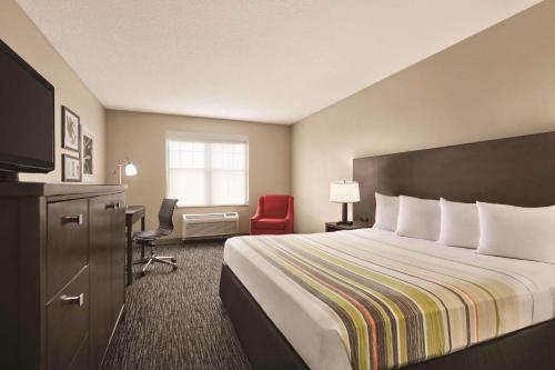 坦帕坦帕江山旅馆及套房的配有一张床和一张书桌的酒店客房