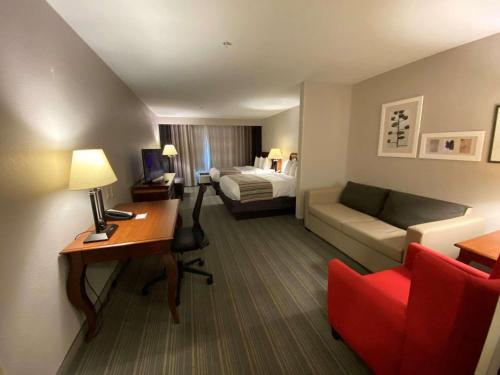 阿森斯雅典江山套房酒店的酒店客房配有书桌、沙发和床。