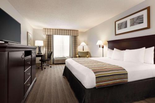 金斯兰金斯兰江山旅馆&套房酒店的酒店客房设有一张大床和一台电视。