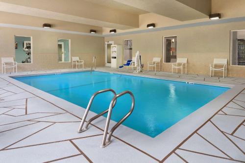 布伦瑞克布伦瑞克乡村套房酒店的一座配有桌椅的酒店游泳池