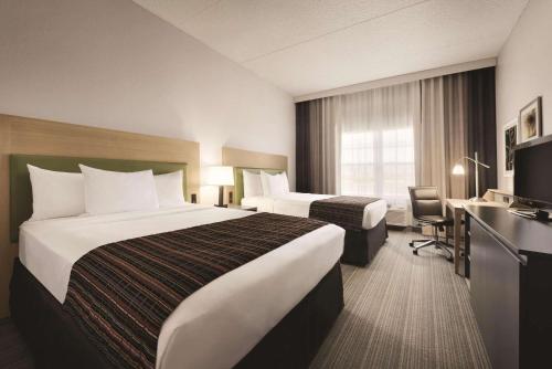 克拉尔维尔卡尔森 - 科拉尔维尔江山旅馆的酒店客房配有两张床和一张书桌