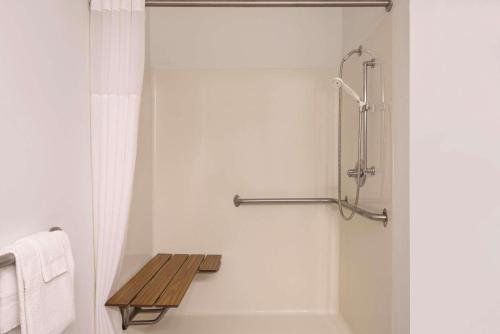 锡达福尔斯卡尔森苏福尔斯江山旅馆的带淋浴的浴室和木制长凳