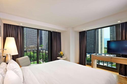 芝加哥芝加哥水楼丽笙酒店的一间卧室配有一张大床和一张书桌及电视