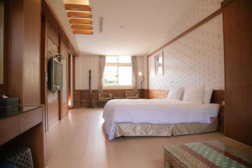 白河关子岭林桂园石泉会馆的酒店客房,配有床和电视