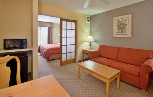 布卢明顿布卢明顿诺默尔西卡尔森江山旅馆及套房酒店的酒店客房配有红色的沙发和床。