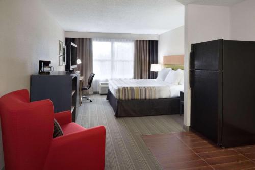 坎普泉江山旅馆及套房卡尔森营温泉的酒店客房,配有一张床和一张红色椅子