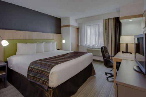 弗雷德里克弗雷德里克卡尔森江山旅馆及套房酒店的酒店客房设有一张大床和一张书桌。