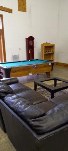 spacious former store的带沙发的客厅配有乒乓球桌