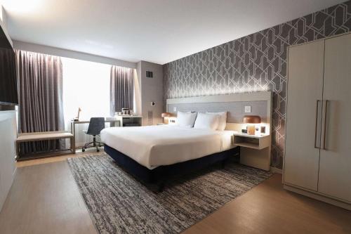 卡拉马祖卡拉马祖中心丽笙广场酒店的酒店客房设有一张大床和一张书桌。
