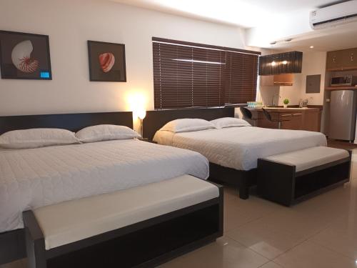 普拉亚布兰卡Playa Blanca的配有厨房的酒店客房内的两张床
