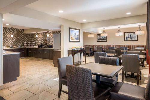 格兰维尔Country Inn & Suites by Radisson, Grandville-Grand Rapids West, MI的一间带桌椅的餐厅和酒吧