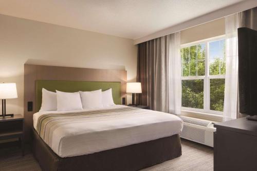 Cottage Grove卡尔森江山酒店 - 可特吉格洛夫的一间卧室设有一张床和一个大窗户