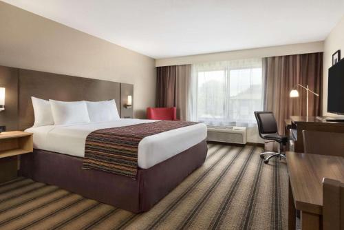 圣克劳德圣克劳德江山套房旅馆的酒店客房设有一张大床和一张书桌。
