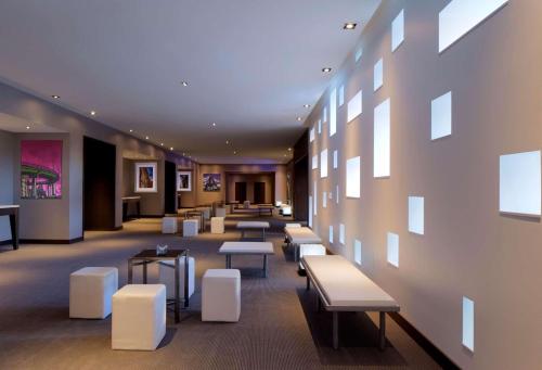 布卢明顿美国商场丽笙酒店的一间设有白色长椅和桌子的等候室