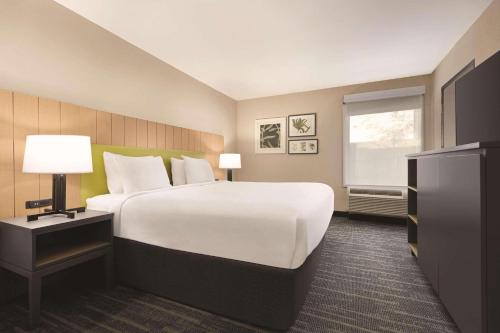 邓恩Country Inn & Suites by Radisson, Dunn, NC的一间设有大床和窗户的酒店客房