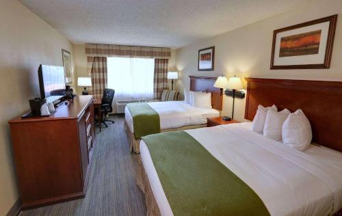 夏洛特卡尔森夏洛特机场乡村旅馆和套房酒店的酒店客房配有两张床和一张书桌
