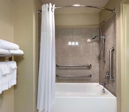 康科德卡尔森康科德/坎纳乡村酒店套房 的带淋浴和白色浴缸的浴室