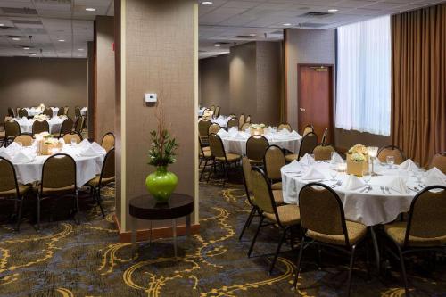俾斯麦丽笙俾斯麦酒店的一间设有白色桌椅和花瓶的用餐室