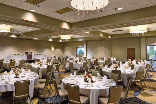 俾斯麦丽笙俾斯麦酒店的宴会厅配有白色的桌椅和吊灯