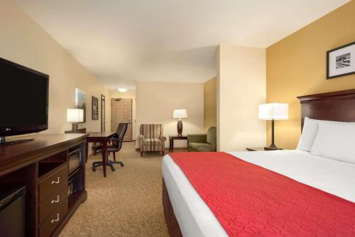 迈诺特迈诺特乡村酒店及套房的配有一张床和一台平面电视的酒店客房
