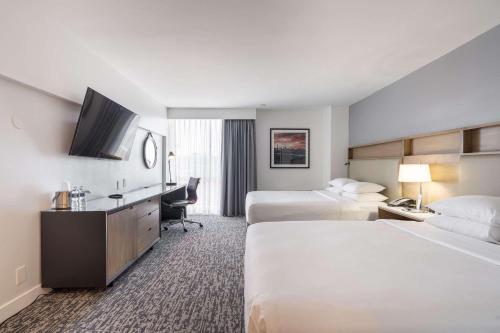 皇后区Radisson Hotel JFK Airport的酒店客房配有两张床和一张书桌