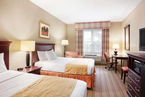 伊萨卡伊萨卡乡村套房酒店的酒店客房配有两张床和一张书桌