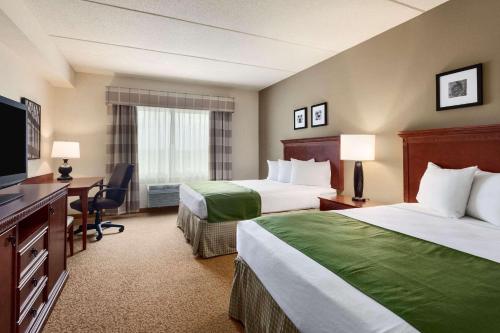西塞尼卡Country Inn & Suites by Radisson, Buffalo South I-90, NY的酒店客房配有两张床和一张书桌