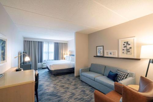 州学院州立学院江山套房旅馆的酒店客房设有一张沙发和一张床