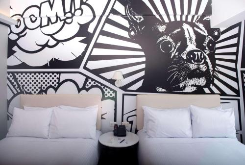 利马Radisson RED Miraflores的一间卧室配有两张床和一只狗的壁画
