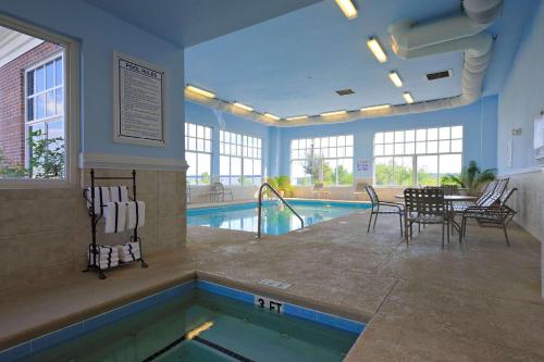 奥兰治堡奥兰治堡乡村套房宾馆的游泳池旁的带桌椅的游泳池
