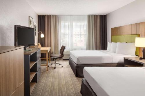 萨默维尔萨默维尔江山旅馆及套房的酒店客房配有两张床和一张书桌