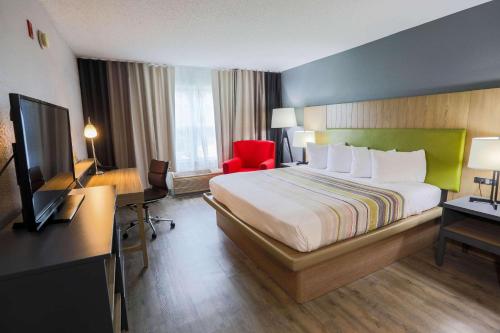 默特尔比奇默特尔比奇江山旅馆的酒店客房配有一张床、一张书桌和一台电视。