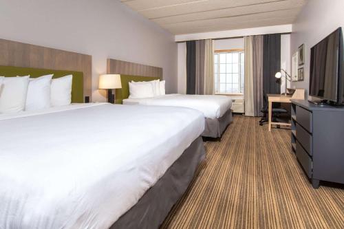 拉皮德城卡尔森湖城江山旅馆的酒店客房设有两张床和一台平面电视。